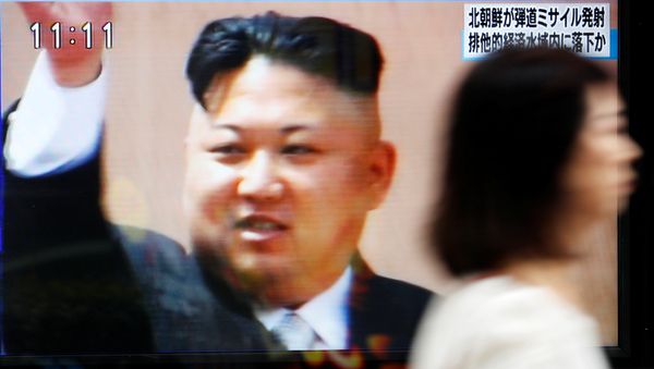 A woman walks past a street monitor in Tokyo, Japan, reporting that North Korea had fired a ballistic missile, in this photo taken by Kyodo July 4, 2017. - Sputnik International