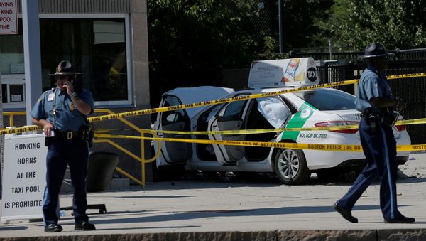 A Massachusetts State Police officer walks past the scene where a taxi cab crashed into a group of bystanders at the taxi pool at Logan International Airport in Boston, Massachusetts, U.S - Sputnik International