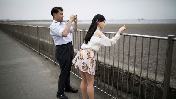 In this picture taken on May 9, 2017, physiotherapist Masayuki Ozaki (L) takes pictures of his silicone sex doll Mayu in Tokyo Bay. - Sputnik International