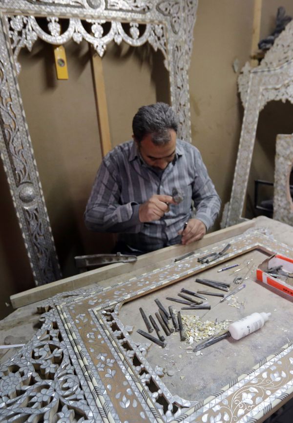 A Syrian artisan etches away at wooden panels inlaid with mother-of-pearl, at a workshop in the capital, Damascus - Sputnik International