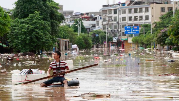 Man using an improvised flotation device to move through floodwaters on a flooded street in Liuzhou, Guangxi province Man using an improvised flotation device to move through floodwaters on a flooded street in Liuzhou, Guangxi province - Sputnik International