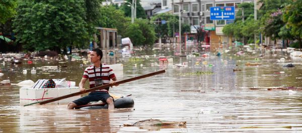 Man using an improvised flotation device to move through floodwaters on a flooded street in Liuzhou, Guangxi province Man using an improvised flotation device to move through floodwaters on a flooded street in Liuzhou, Guangxi province - Sputnik International