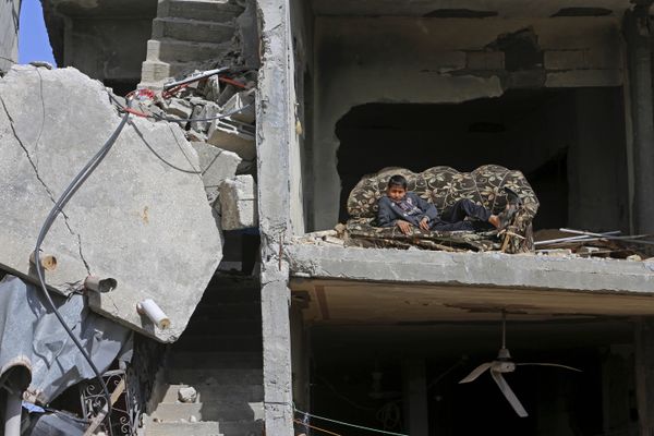 Mohammed Keferna, 14, sits on a couch in his family's building that was damaged by Israeli strikes during last summer's Israel-Hamas war, in Beit Hanoun, northern Gaza Strip, Friday, Jan. 30, 2015 - Sputnik International