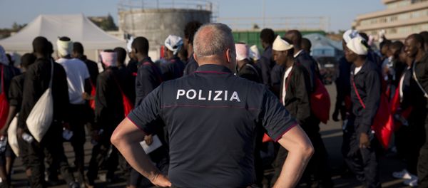 An Italian border police officer escorts sub Saharan men on their way to a relocation center, after arriving in the Golfo Azzurro rescue vessel at the port of Augusta, in Sicily, Italy, with hundreds of migrants aboard, rescued by members of Proactive Open Arms NGO, on Friday, June 23, 2017 An Italian border police officer escorts sub Saharan men on their way to a relocation center, after arriving in the Golfo Azzurro rescue vessel at the port of Augusta, in Sicily, Italy, with hundreds of migrants aboard, rescued by members of Proactive Open Arms NGO, on Friday, June 23, 2017 - Sputnik International