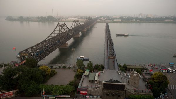 The sun sets over the Friendship bridge on the Yalu River connecting the North Korean town of Sinuiju and Dandong in Chinese border city of Dandong on July 5, 2017 - Sputnik International