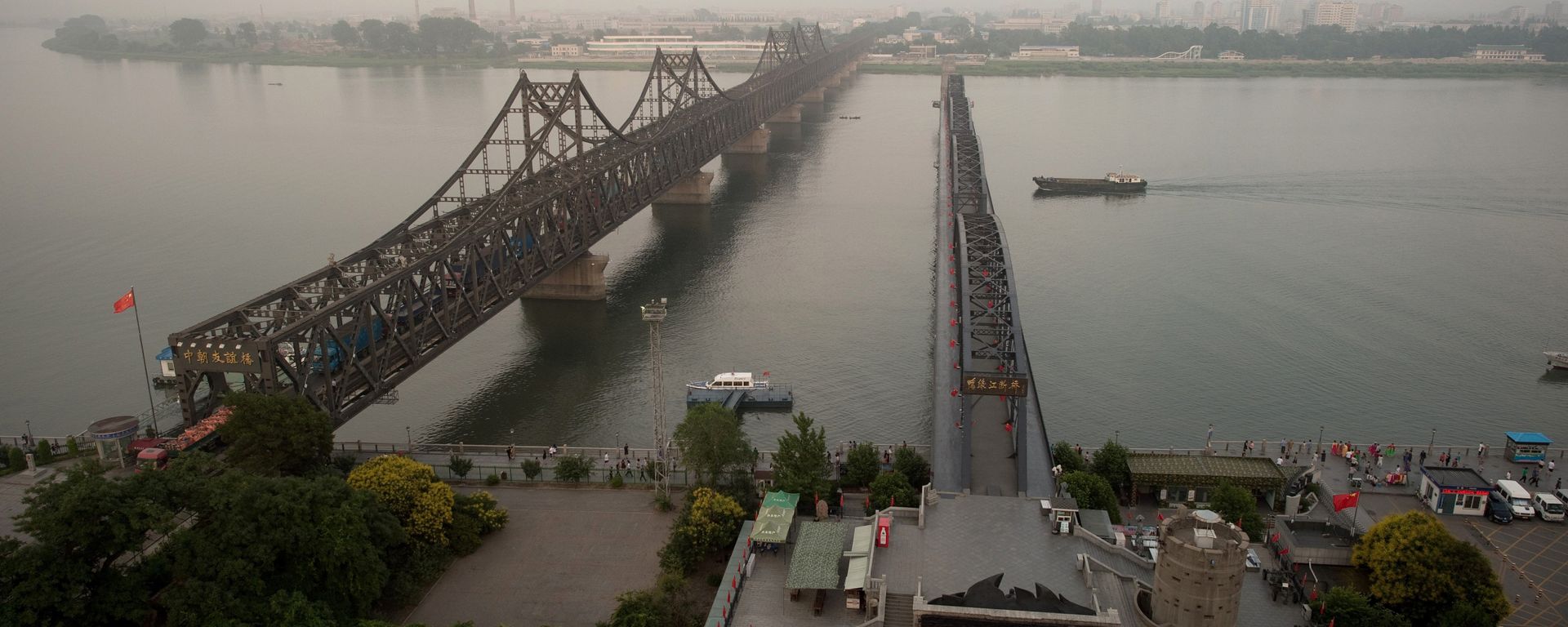 The sun sets over the Friendship bridge on the Yalu River connecting the North Korean town of Sinuiju and Dandong in Chinese border city of Dandong on July 5, 2017 The sun sets over the Friendship bridge on the Yalu River connecting the North Korean town of Sinuiju and Dandong in Chinese border city of Dandong on July 5, 2017 - Sputnik International, 1920, 04.11.2021