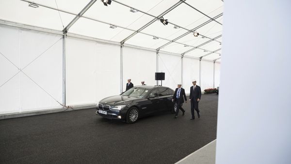 Security personnel walk along a vehicle transporting Chinese President Xi Jinping as he leaves following his visit to a section of the Hong Kong-Zhuhai-Macau Bridge which is under construction in Hong Kong Saturday, July 1, 2017 - Sputnik International