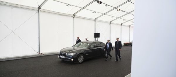 Security personnel walk along a vehicle transporting Chinese President Xi Jinping as he leaves following his visit to a section of the Hong Kong-Zhuhai-Macau Bridge which is under construction in Hong Kong Saturday, July 1, 2017 - Sputnik International