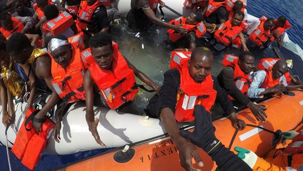 Migrants on a dinghy are rescued by Save the Children NGO crew from the ship Vos Hestia in the Mediterranean sea off Libya coast, June 17, 2017 - Sputnik International
