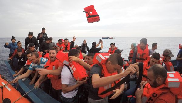 Migrants on wooden boat being rescued by Save the Children NGO crew from the ship Vos Hestia in the Mediterranean sea off Libya coast, June 18, 2017 - Sputnik International
