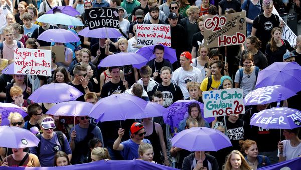 People hold banners and umbrellas as they walk during the protest demonstration at the G20 summit in Hamburg, Germany, July 7, 2017 People hold banners and umbrellas as they walk during the protest demonstration at the G20 summit in Hamburg, Germany, July 7, 2017 - Sputnik International