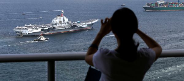 An onlooker takes a photo as China's aircraft carrier Liaoning sails into Hong Kong, China July 7, 2017 - Sputnik International