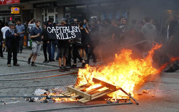 A protester holds a banner next to the bonfire during a demonstration at the G20 summit in Hamburg, Germany, July 7, 2017 A protester holds a banner next to the bonfire during a demonstration at the G20 summit in Hamburg, Germany, July 7, 2017 - Sputnik International