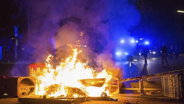 Policemen stand behind a burning barricade in the so-called 'Schanzenviertel' area, on the sidelines of the G-20 summit, early Sunday, July 9, 2017, in Hamburg. Policemen stand behind a burning barricade in the so-called 'Schanzenviertel' area, on the sidelines of the G-20 summit, early Sunday, July 9, 2017, in Hamburg. - Sputnik International