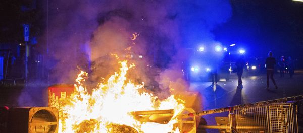 Policemen stand behind a burning barricade in the so-called 'Schanzenviertel' area, on the sidelines of the G-20 summit, early Sunday, July 9, 2017, in Hamburg. Policemen stand behind a burning barricade in the so-called 'Schanzenviertel' area, on the sidelines of the G-20 summit, early Sunday, July 9, 2017, in Hamburg. - Sputnik International