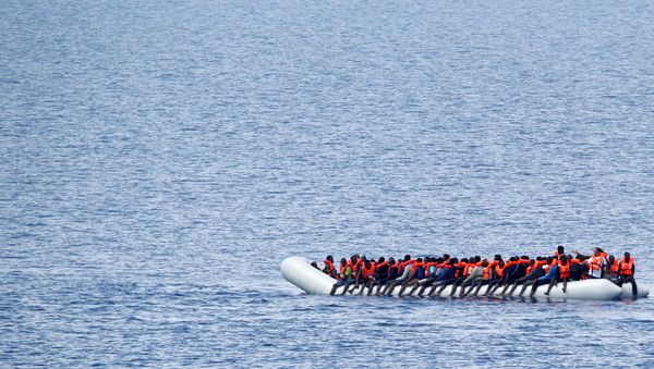 Migrants wait to be rescued by Save the Children NGO crew in the Mediterranean sea off Libya coast, June 18, 2017. - Sputnik International
