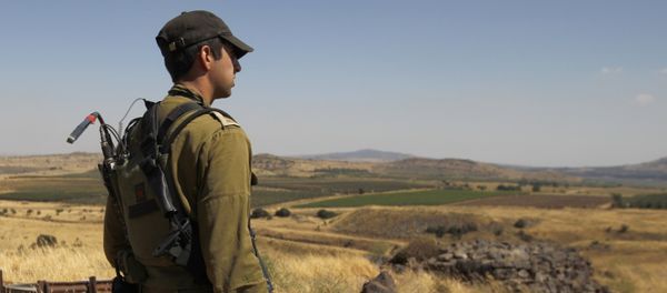 A Israeli soldier patrols near the border with Syria after projectiles fired from the war-torn country hit the Israeli occupied Golan Heights on June 24, 2017 A Israeli soldier patrols near the border with Syria after projectiles fired from the war-torn country hit the Israeli occupied Golan Heights on June 24, 2017 - Sputnik International