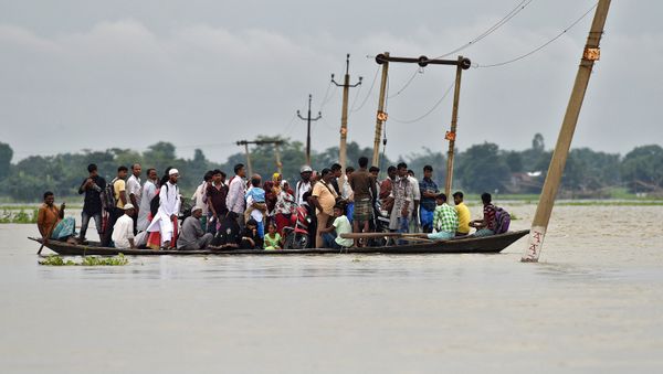 Villagers use a boat to cross a flooded road at Asigarh village in Morigaon district in the northeastern state of Assam, India, July 4, 2017 Villagers use a boat to cross a flooded road at Asigarh village in Morigaon district in the northeastern state of Assam, India, July 4, 2017 - Sputnik International