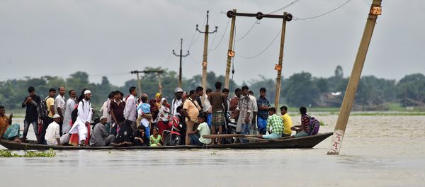 Villagers use a boat to cross a flooded road at Asigarh village in Morigaon district in the northeastern state of Assam, India, July 4, 2017 - Sputnik International