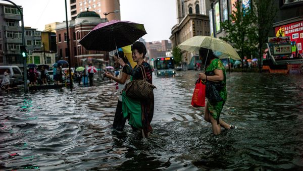 Women cross a flooded street after a heavy rain in Shenyang, Liaoning province on July 14, 2017 Women cross a flooded street after a heavy rain in Shenyang, Liaoning province on July 14, 2017 - Sputnik International