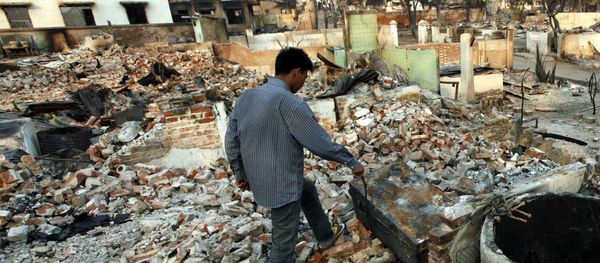 A man walks among debris of buildings destroyed during ethnic unrest between Buddhists and Muslim in Meikhtila, about 550 kilometers (340 miles) north of Yangon, Myanmar, Monday, March 25, 2013 - Sputnik International