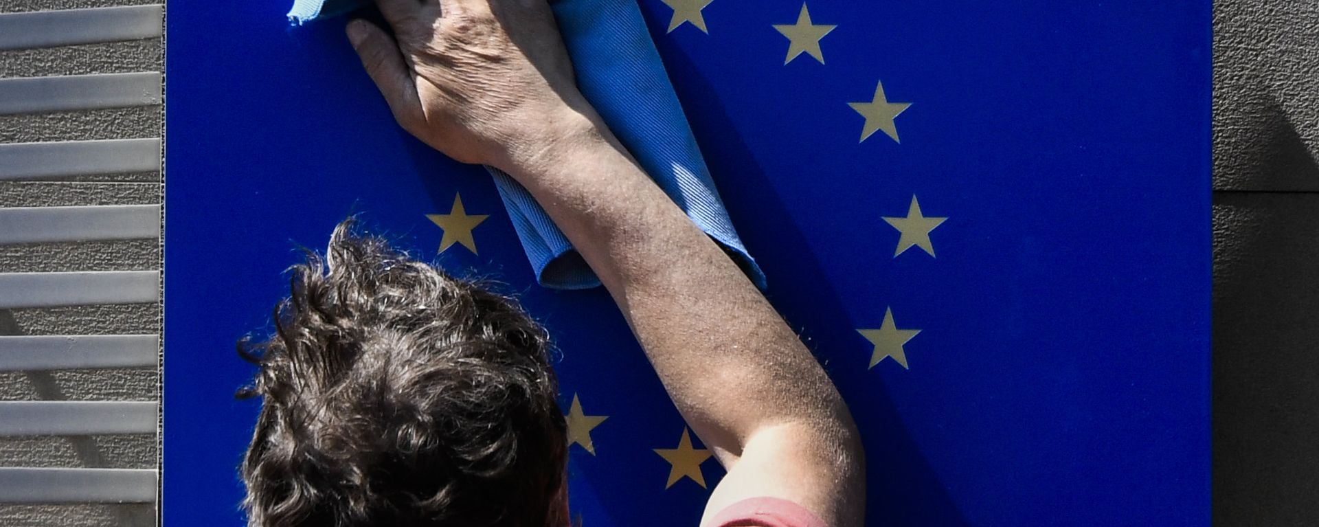 A worker wipes an EU flag clean. A worker wipes an EU flag clean. - Sputnik International, 1920, 16.09.2021