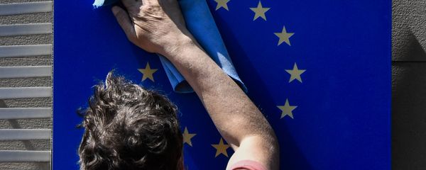 A worker wipes an EU flag clean. A worker wipes an EU flag clean. - Sputnik International