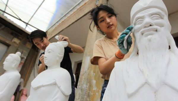 The couple clear dust and repair cracks after the sculptures have been painted with putty. Photo:Yang Hui/GT - Sputnik International