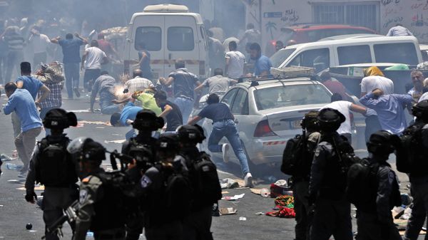 Palestinian worshippers run for cover from teargas, fired by Israeli forces, following prayers outside Jerusalem's Old City in front of the Al-Aqsa mosque compound after Israeli police barred men under 50 from entering the Old City for Friday Muslim prayers as tensions rose and protests erupted over new security measures at the highly sensitive holy site on July 21, 2017.  - Sputnik International
