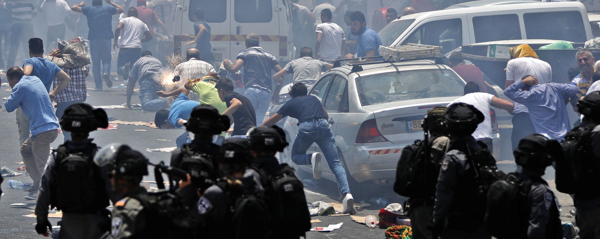 Palestinian worshippers run for cover from teargas, fired by Israeli forces, following prayers outside Jerusalem's Old City in front of the Al-Aqsa mosque compound after Israeli police barred men under 50 from entering the Old City for Friday Muslim prayers as tensions rose and protests erupted over new security measures at the highly sensitive holy site on July 21, 2017.  - Sputnik International, 1920, 23.06.2022