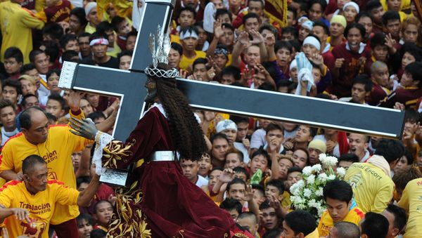 Catholic devotees carry the life-size statue of the Black Nazarene (C) to a carriage during an annual procession in honor of the centuries-old icon of Jesus Christ in Manila on January 9, 2013. - Sputnik International