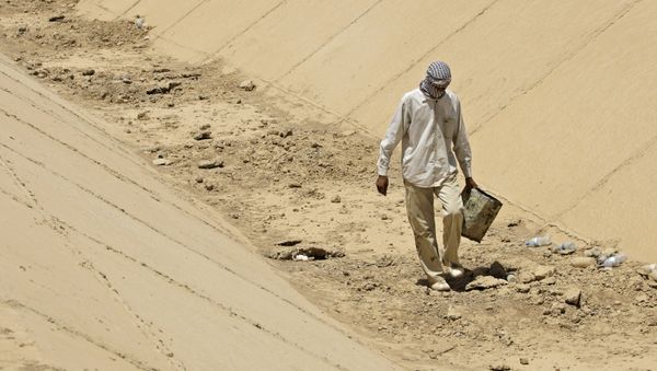 In this photo taken Thursday, July 9, 2009, Abbas Mohammed, walks throw a dray canal in Latifiyah, about 30 kilometers (20 miles) south of Baghdad, Iraq. Below-average rainfall and insufficient water in the Euphrates and Tigris rivers - something the Iraqis have blamed on dams in neighboring Turkey and Syria - have left Iraq bone-dry for a second straight year. In this photo taken Thursday, July 9, 2009, Abbas Mohammed, walks throw a dray canal in Latifiyah, about 30 kilometers (20 miles) south of Baghdad, Iraq. Below-average rainfall and insufficient water in the Euphrates and Tigris rivers - something the Iraqis have blamed on dams in neighboring Turkey and Syria - have left Iraq bone-dry for a second straight year. - Sputnik International