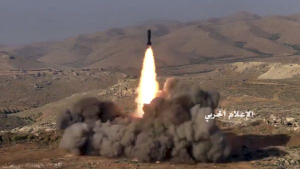 This frame grab from video released on Saturday, July 22, 2017 and provided by the government-controlled Syrian Central Military Media, shows Hezbollah fighters firing a missile at positions of al-Qaida-linked militants in an area on the Lebanon-Syria border - Sputnik International