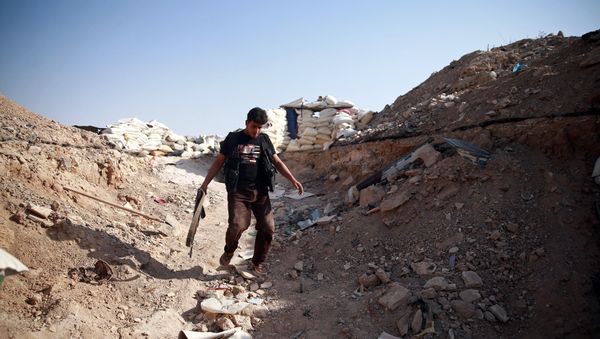A fighter from Free Syrian Army's Al Rahman legion walks near piled sandbags in Ain Tarma, eastern Damascus suburb of Ghouta, Syria July 17, 2017 - Sputnik International