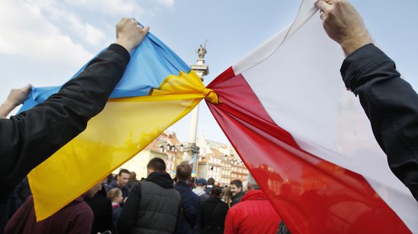 People hold tied Polish, right, and Ukrainian flags during a demonstration supporting the opposition movement in Ukraine, in Warsaw, Poland, Sunday, Feb. 23, 2014 - Sputnik International
