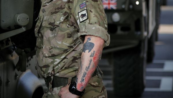 A British serviceman, his arm tattooed with poppies that reads We Will Remember Them stands near vehicles in the Romanian border checkpoint in Giurgiu, Romania, Thursday, June 1, 2017 to take part in the alliance's Noble Jump 2017 exercise which tests the readiness of alliance troops. - Sputnik International