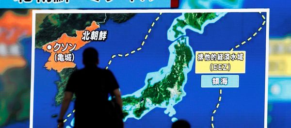 Men walk past a street monitor showing news of North Korea's intercontinental ballistic missile test in Tokyo, Japan. (File) - Sputnik International