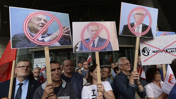 People demonstrate, outside the office of the ruling party leader Jaroslaw Kaczynski, holding banners with the images of from left, financier George Soros ,President of the European Council Donald Tusk and First Vice-President of the European Commission Frans Timmermans, during a protest, in Warsaw, Poland, Wednesday, July 26, 2017 People demonstrate, outside the office of the ruling party leader Jaroslaw Kaczynski, holding banners with the images of from left, financier George Soros ,President of the European Council Donald Tusk and First Vice-President of the European Commission Frans Timmermans, during a protest, in Warsaw, Poland, Wednesday, July 26, 2017 - Sputnik International