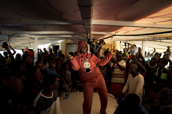A woman from Nigeria dances on the deck of the Golfo Azzurro rescue vessel as it arrives at the port of Pozzallo, south of Sicily, Italy, with hundreds of migrants aboard, rescued by members of Proactive Open Arms NGO, on Saturday, June.17, 2017 - Sputnik International