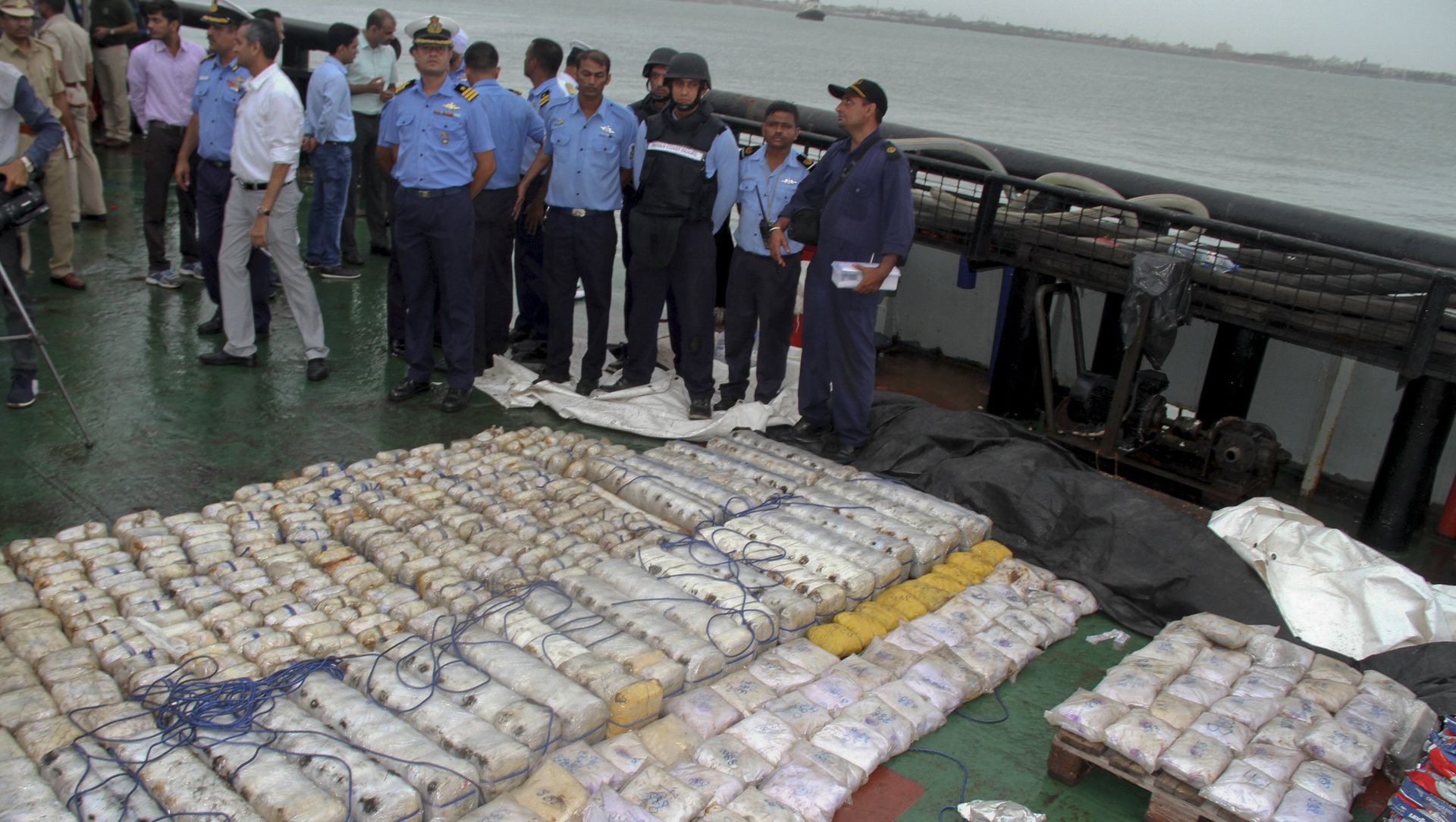 In this Sunday, July 30, 2017 photo, Indian coast guard officials, in blue, stand next to a massive amount of heroin they claim to have seized from a ship off the country's western coast near Porbandar, India In this Sunday, July 30, 2017 photo, Indian coast guard officials, in blue, stand next to a massive amount of heroin they claim to have seized from a ship off the country's western coast near Porbandar, India - Sputnik International, 1920, 15.04.2021