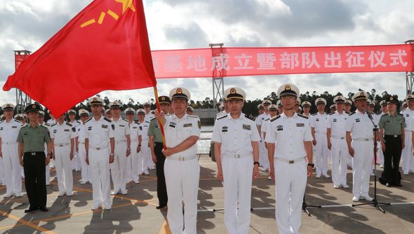 A soldier of China's People's Liberation Army (PLA) is holding a PLA flag as others stand guard at a military port in Zhanjiang, Guangdong province, China, July 11, 2017 - Sputnik International