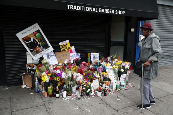 A woman looks at floral tributes laid after the death of Rashan Charles outside a shop in east London - Sputnik International