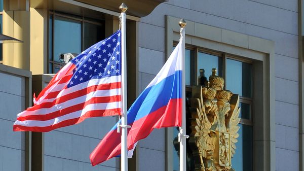 This photo taken on May 7, 2013 shows Russian and the US flags running up as the US Secretary of State arrives at Moscow Vnukovo Airport - Sputnik International