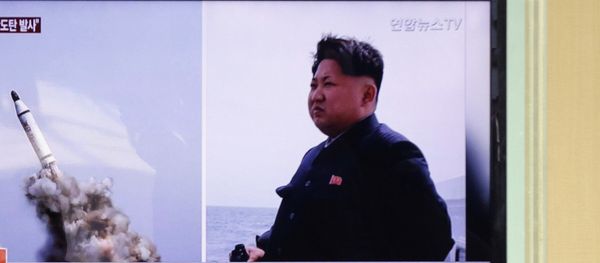 South Korean men pass by a TV news program showing images published in North Korea's Rodong Sinmun newspaper of North Korea's ballistic missile believed to have been launched from underwater and North Korean leader Kim Jong-un, at Seoul Railway station in Seoul, South Korea, Saturday, May 9, 2015 - Sputnik International