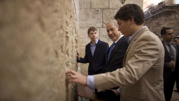 In this Jan. 22, 2013 file photo, Israeli Prime Minister Benjamin Netanyahu, center, prays with his sons Yair, background, and Avner, right, at the Western Wall, the holiest site where Jews can pray, in Jerusalem's Old City. - Sputnik International