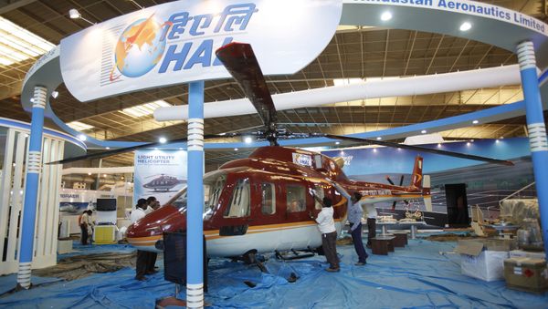 Workers polish a helicopter at the stall of Hindustan Aeronautics Ltd. on the eve of Aero India 2011 at Yelahanka air base on the outskirts of Bangalore, India. (File) - Sputnik International