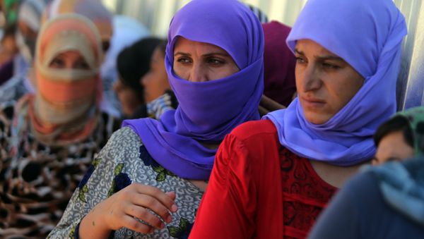 Yazidi Iraqi women queue in order to get food at the Bajid Kandala camp near the Tigris River, in Kurdistan's western Dohuk province, where they took refuge after fleeing advances by Islamic State jihadists in Iraq on August 13, 2014. (File) - Sputnik International