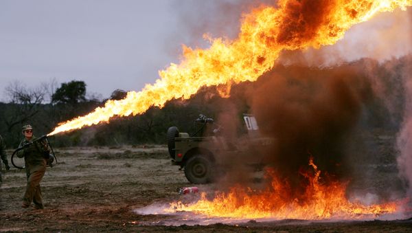 Sunni Michael demonstrates a flamethrower that will be used in a re-enactment of the battle of Iwo Jima, marking the 60th anniversary, on a Hill Country ranch in Doss, Texas. (File) - Sputnik International