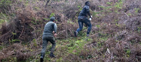 A member of the Moroccan authorities runs after a migrant on February 18, 2017 after he forced his way through a fence between Morocco and the tiny Spanish enclave of Ceuta A member of the Moroccan authorities runs after a migrant on February 18, 2017 after he forced his way through a fence between Morocco and the tiny Spanish enclave of Ceuta - Sputnik International