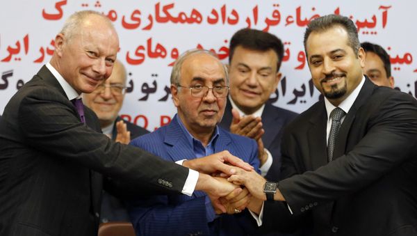 (L to R) Thierry Bollore, deputy director of Competitiveness at Renault, Mansour Moazami, Chairman of the Board of Directors of IDRO Group, and Kourosh Morshed Solouk, deputy director of the Iranian Automobile Importers Association, shake hands as they attend a signing of a deal ceremony in Tehran on August 7, 2017 - Sputnik International